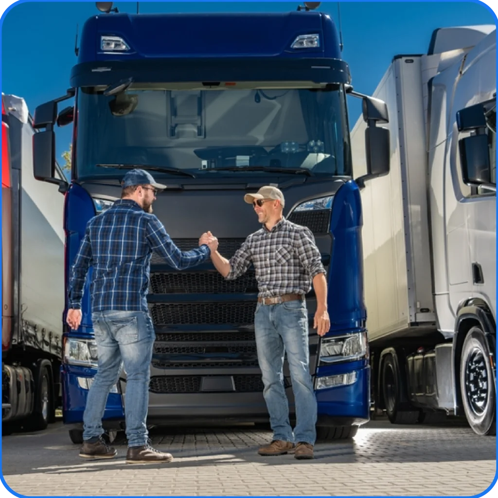 Two men shaking hands in front of blue and white trucks, truck rental Dubai and recovery truck services