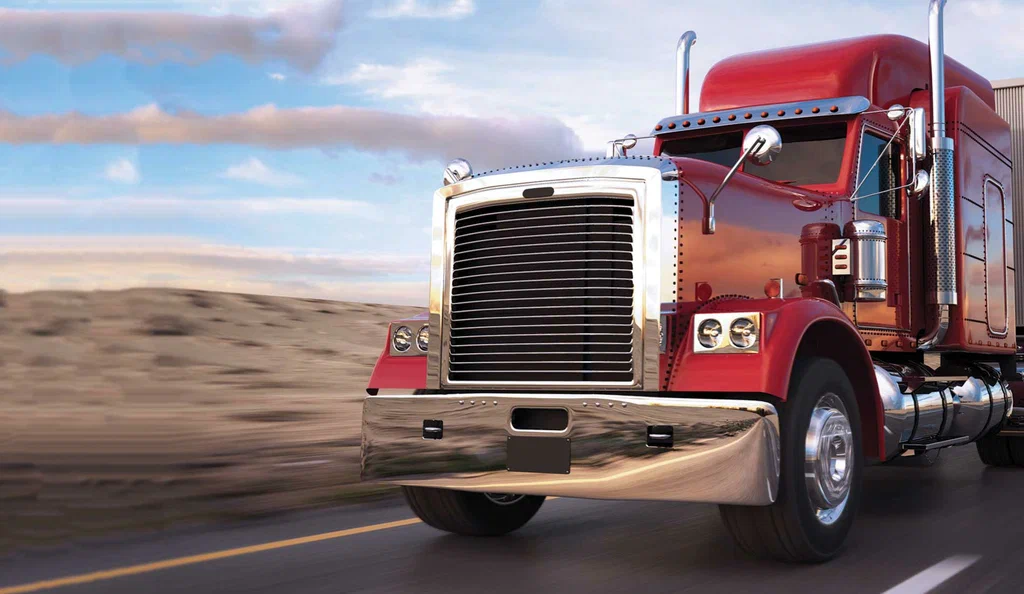 A red semi-truck speeds along a highway against a vast desert landscape under a partly cloudy blue sky, representing heavy truck rental Dubai services and conveying motion and freedom.